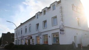 A white building with multiple windows and a sign that reads "HOTEL". - Godorfer Mühle (Cologne)