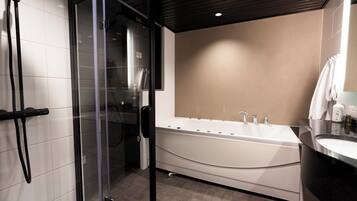 A modern bathroom with a glass-enclosed shower, a freestanding bathtub, and a vanity with a mirror.