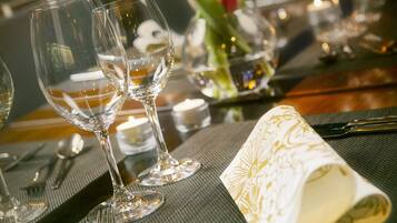 Une table dressée avec des verres à vin, des couverts et une serviette pliée.