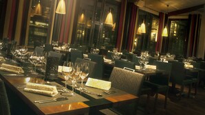 A restaurant with multiple tables set for dining, featuring a modern interior with patterned chairs and ambient lighting. - Hotel Lasaretti (Oulu)