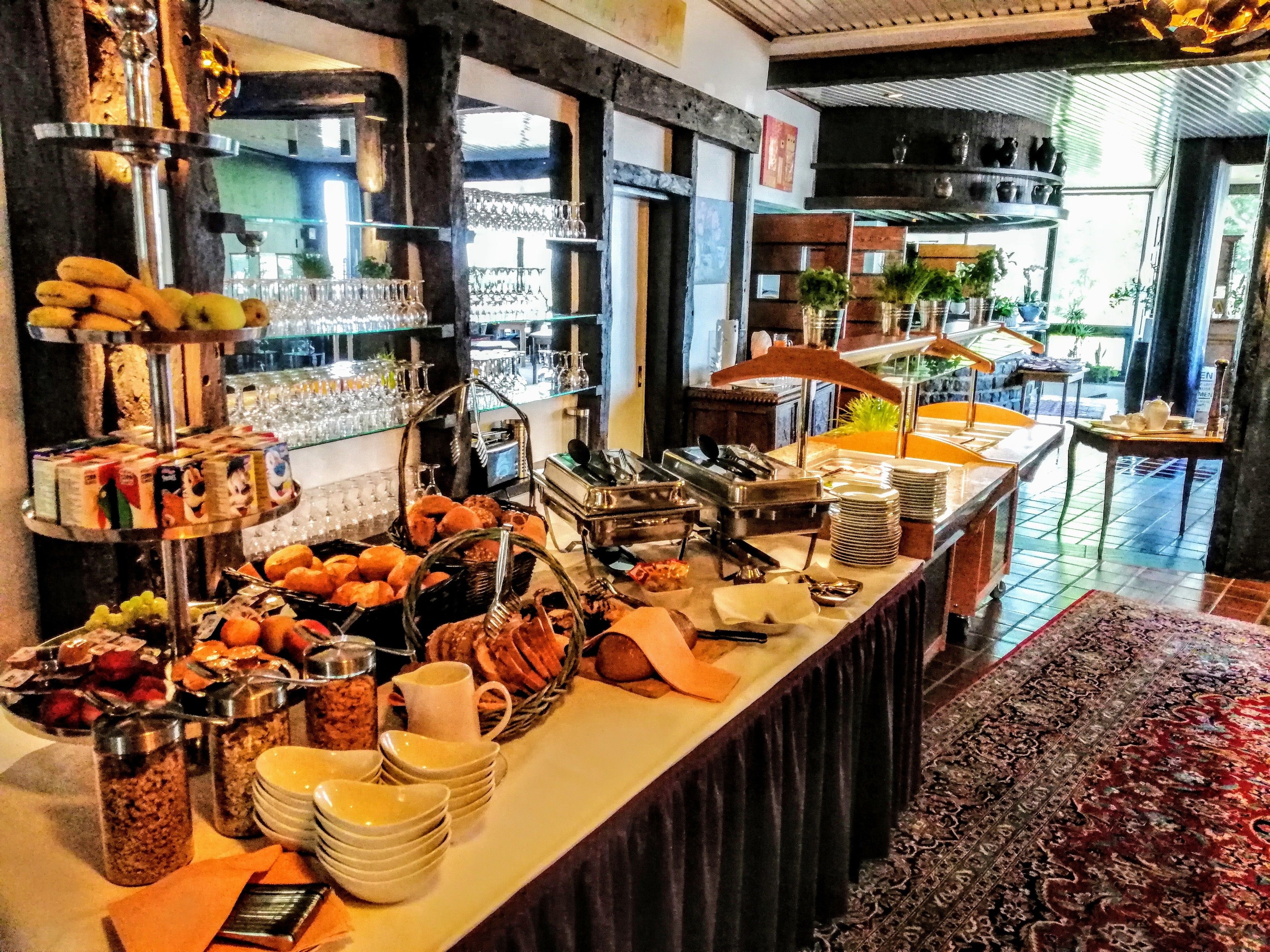 A buffet setup with various food items and utensils.