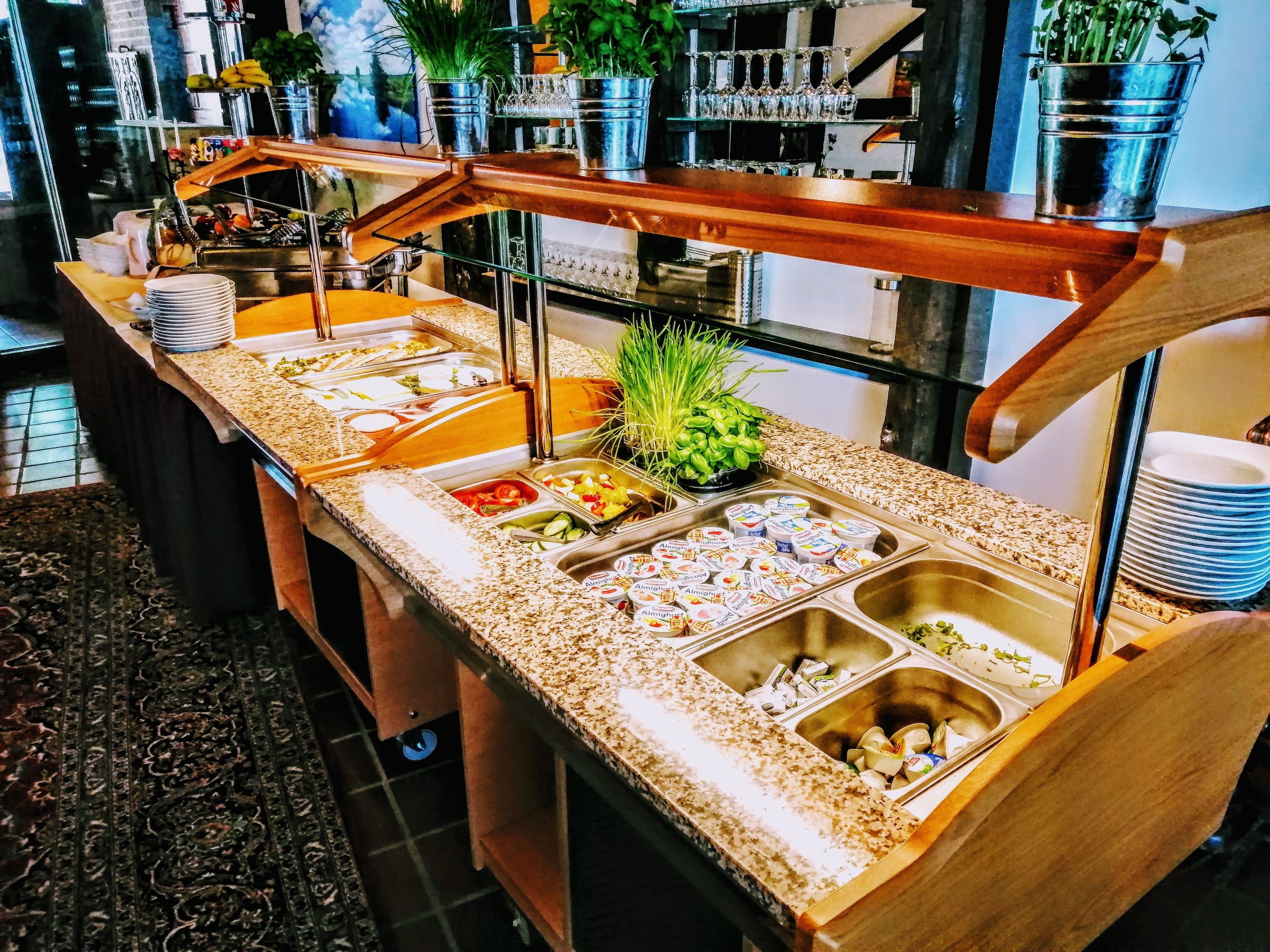 A buffet setup with multiple food stations, including a salad bar and yogurt containers.