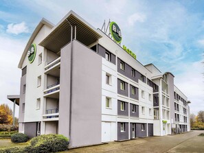 A modern hotel building with multiple floors, balconies, and a prominent B&B Hotels sign.