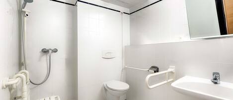 A modern bathroom with a shower, toilet, and sink.