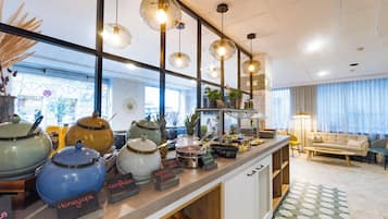 A kitchen area with various cooking utensils, a coffee station, and a seating area with a sofa and a table.