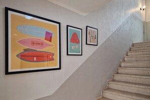 A staircase with a handrail and a wall with three framed artworks. - Garner Hotel Cologne Engelbertz by IHG (Cologne)