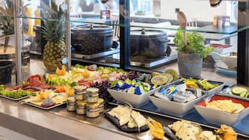 Een buffet met diverse soorten eten, waaronder fruit, kazen en salades.