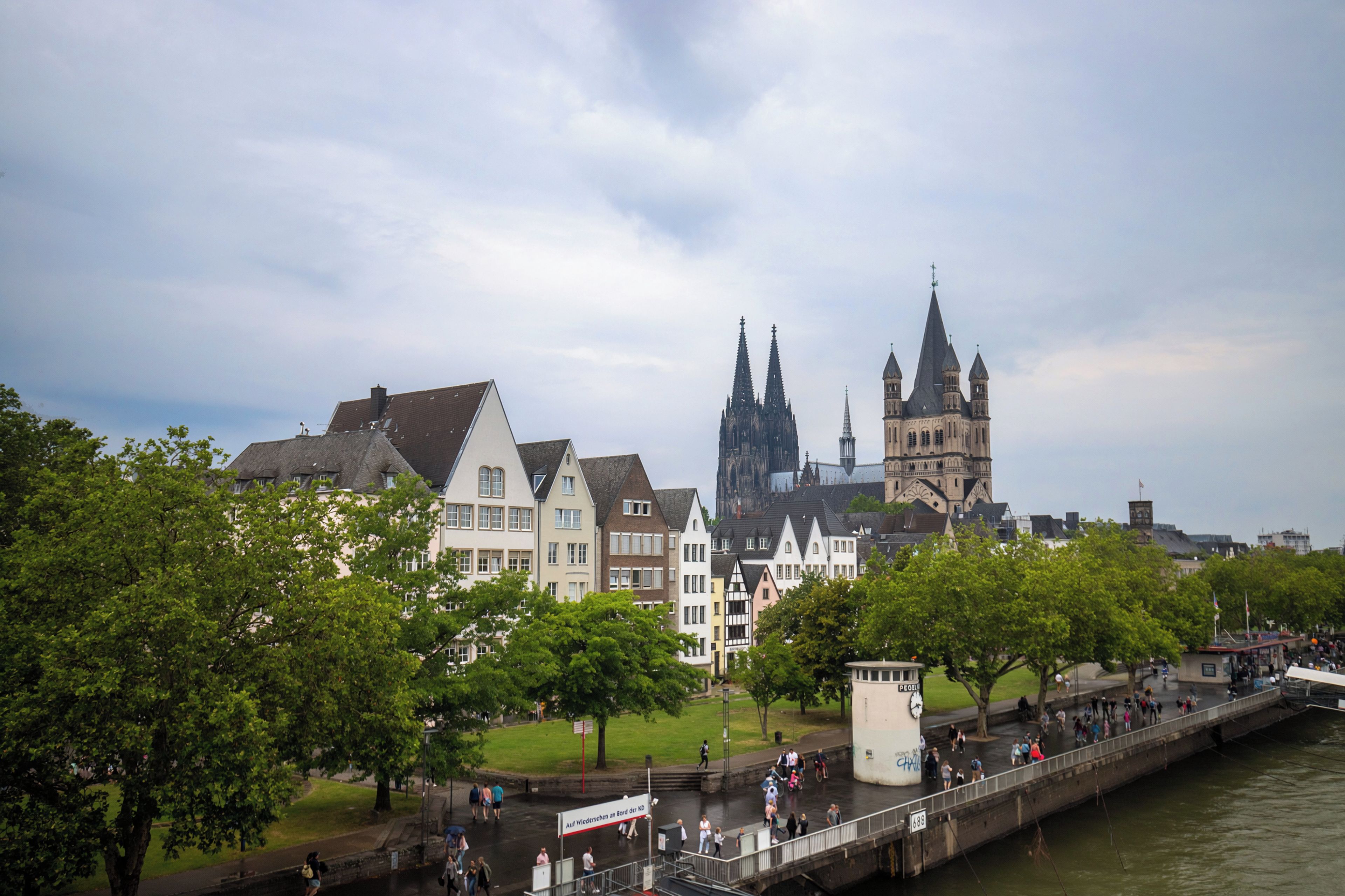 A riverside view of a historic town with traditional buildings and a prominent church tower.