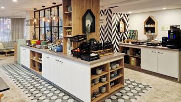 A modern kitchen area with a central island, wooden shelves, and a coffee machine.