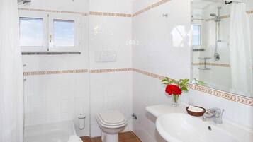 Ein Badezimmer mit einer Badewanne, Toilette und Waschbecken.