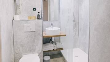 Un baño moderno con inodoro, lavamanos y ducha.