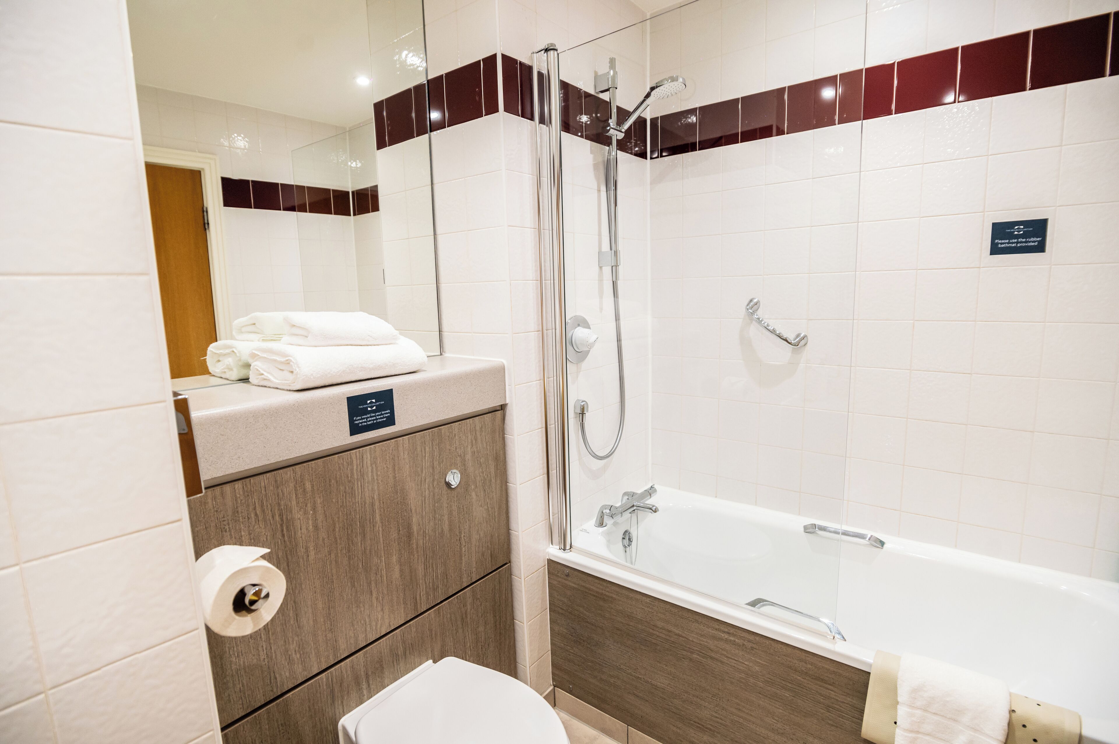 Een moderne badkamer met een bad, douche en toilet.