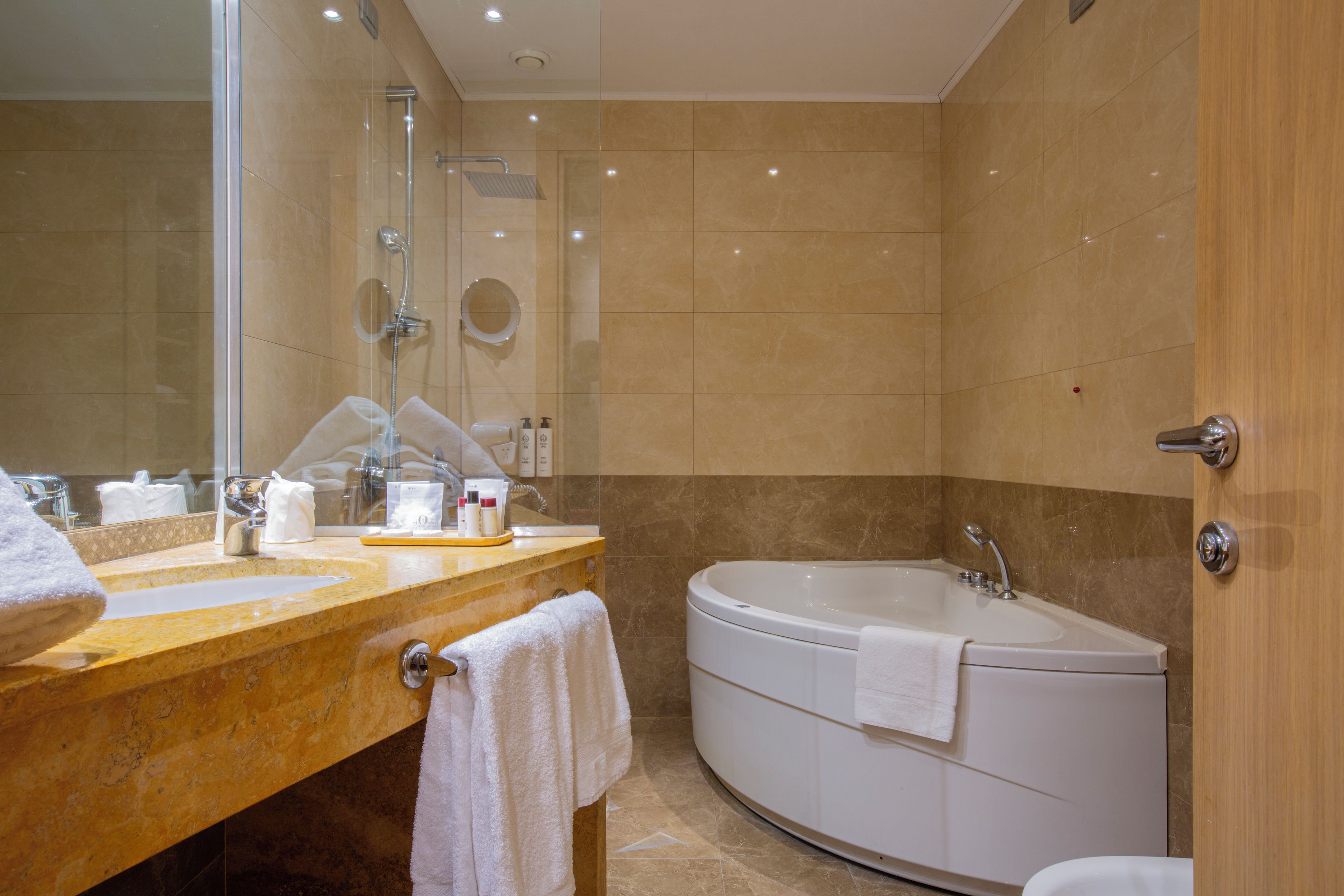 Un bagno moderno con due lavandini, una vasca e uno specchio grande.