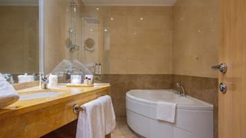 Un bagno moderno con due lavandini, una vasca e uno specchio grande.