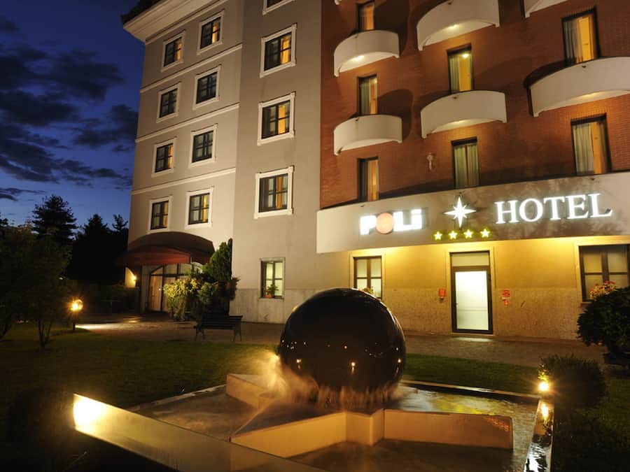 A hotel with a sign reading "POL HOTEL" and a water feature in the foreground.