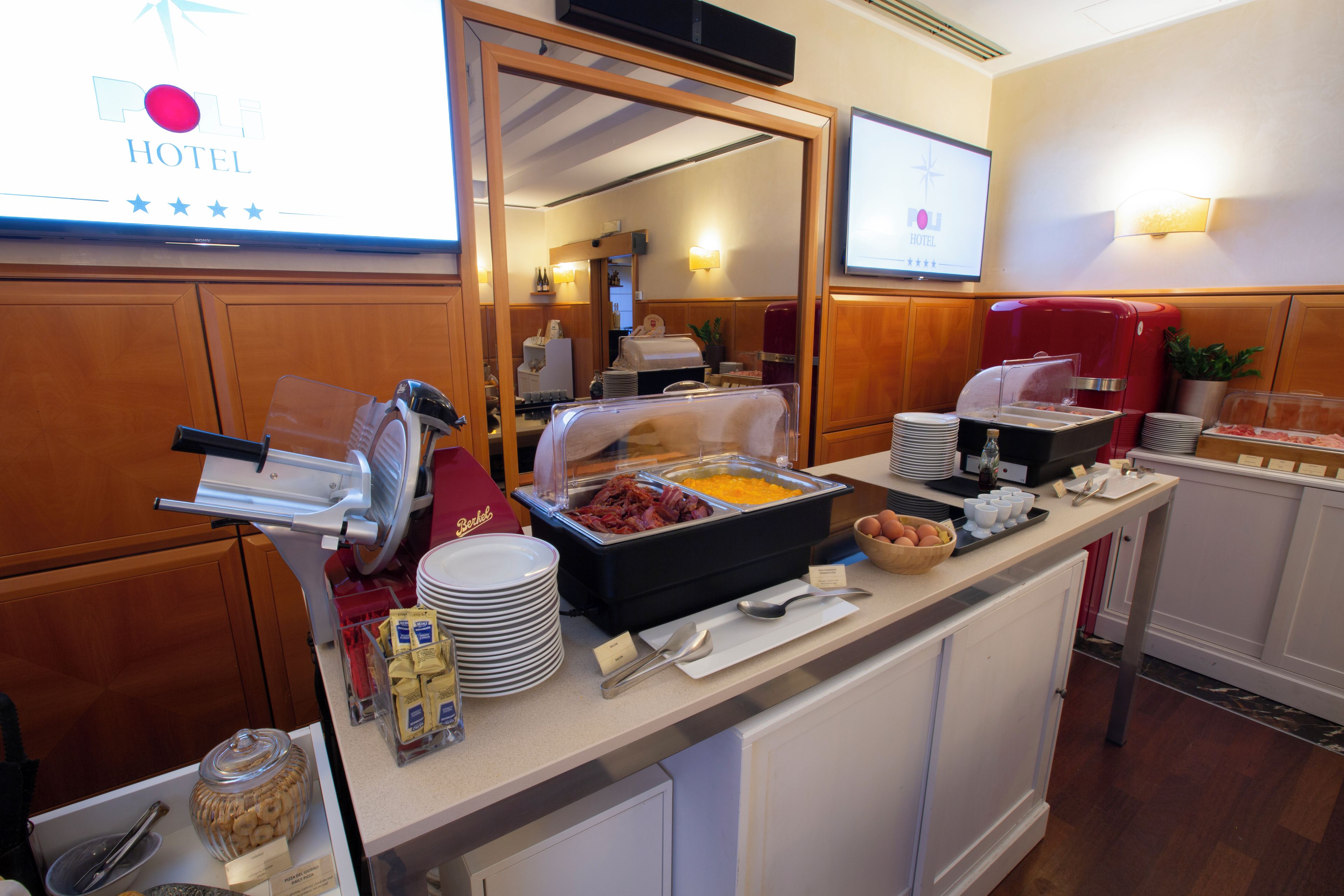 Ein reichhaltiges Frühstücksbuffet im Hotel mit verschiedenen Speisen, darunter Fleisch, Käse und Gebäck.
