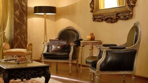 A luxurious room with ornate furniture, including a grand armchair, a smaller chair, and a table with a chess set. - Acropolis Museum Boutique Hotel (Athens)