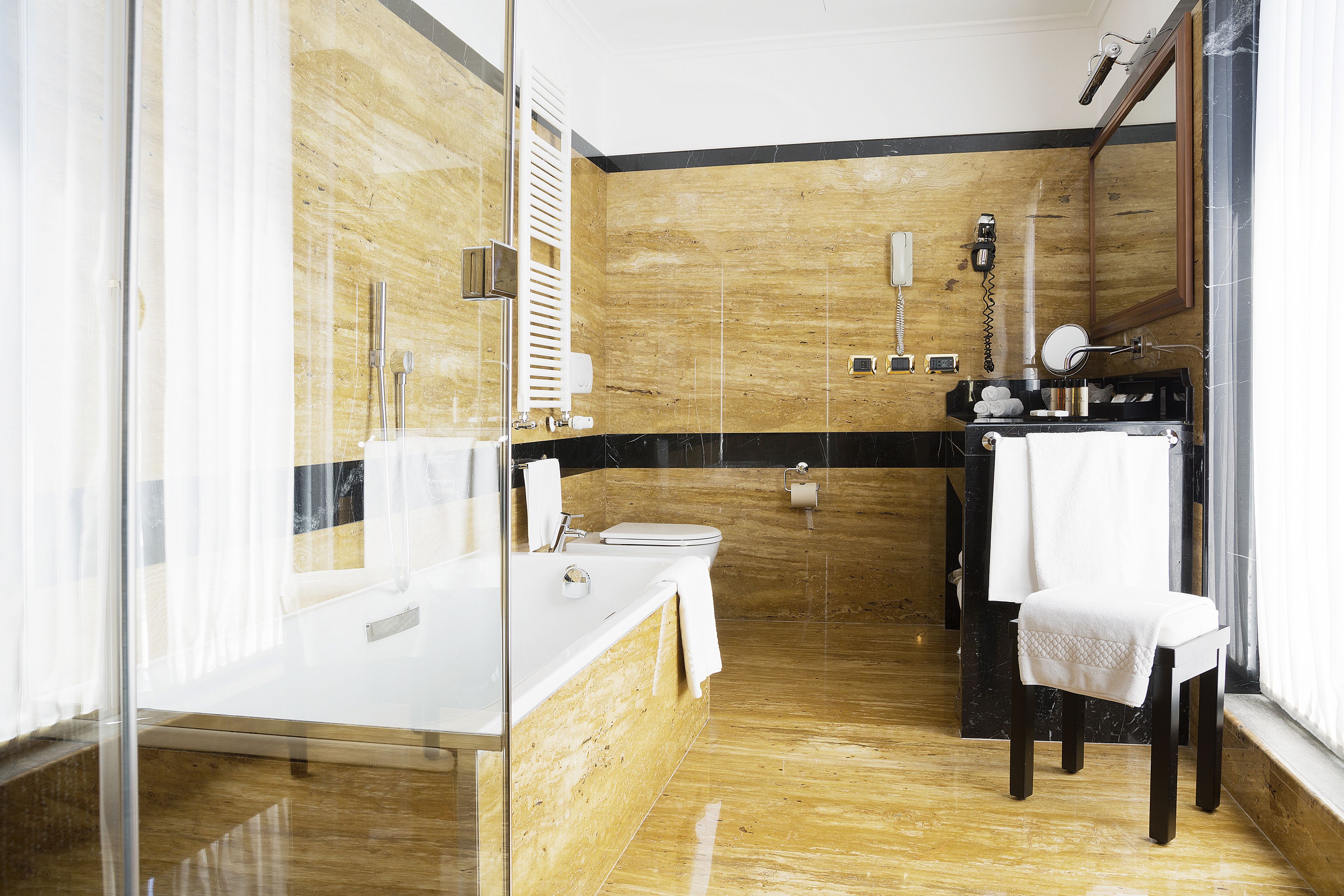 Une salle de bain moderne avec un meuble-lavabo en bois, une cabine de douche en verre et un grand miroir.