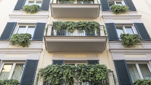Un edificio de varios pisos con balcones cubiertos de follaje.