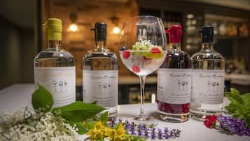 A table with five bottles of Buck Brothers gin and a glass of cocktail.