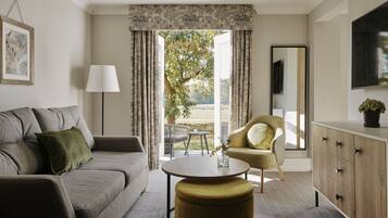 A modern living room with a grey sofa, a round coffee table, a yellow armchair, and a cabinet with drawers.
