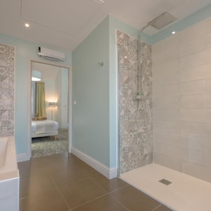 A bathroom with a shower, tiled walls, and a visible air conditioning unit. - Arcantis Hotel Heritage (Cognac)