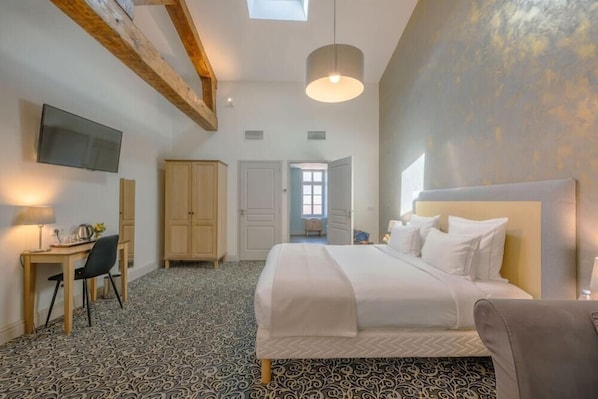 A bedroom with a bed, a desk, a chair, a television, and a wardrobe. - Arcantis Hotel Heritage (Cognac)