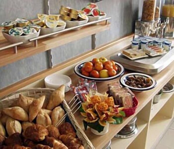 A buffet with various food items including fruits, pastries, and condiments. - Arcantis Hotel Heritage (Cognac)
