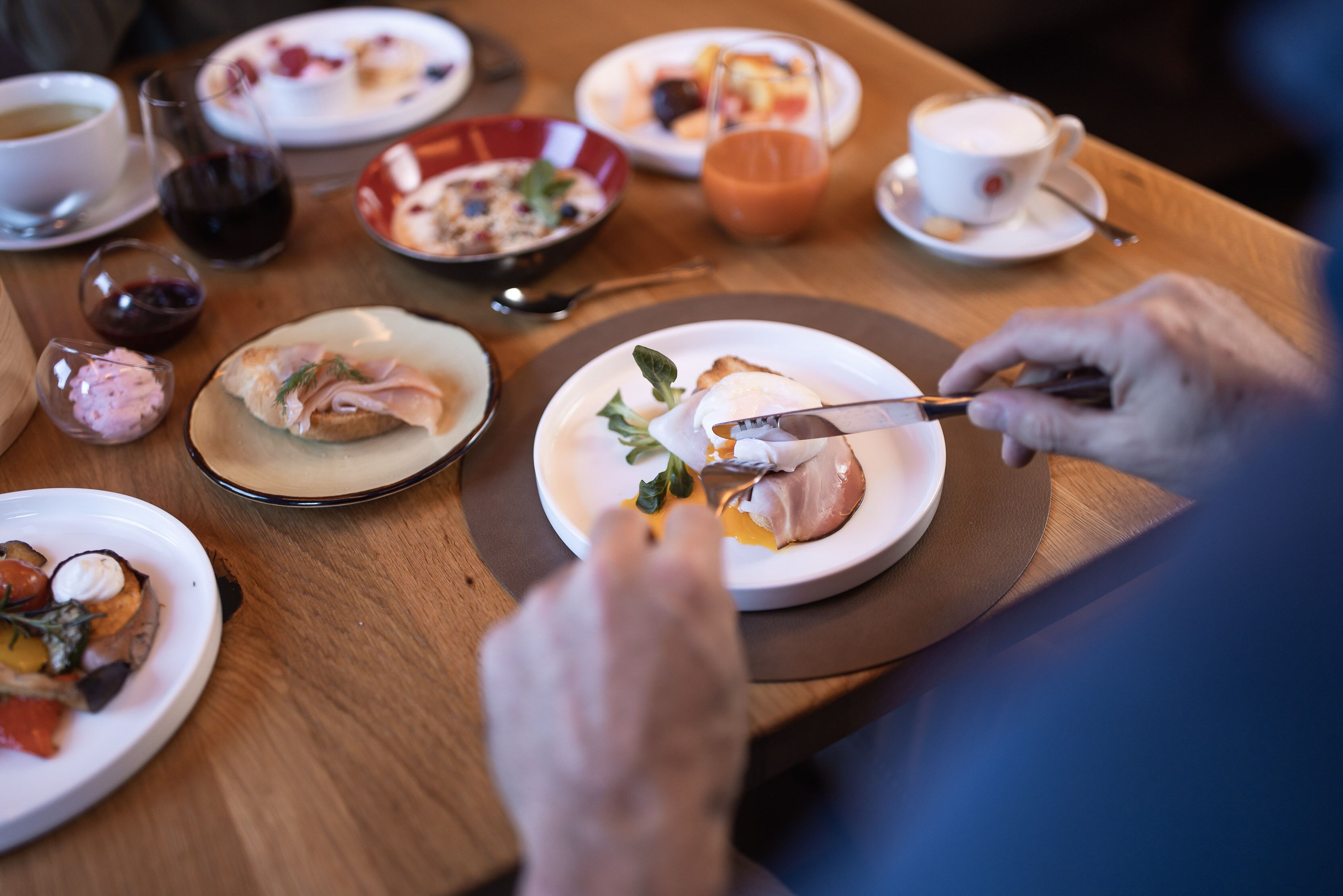 A dining table with various dishes and drinks, including a plate with food and a cup of coffee.