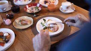A dining table with various dishes and drinks, including a plate with food and a cup of coffee.