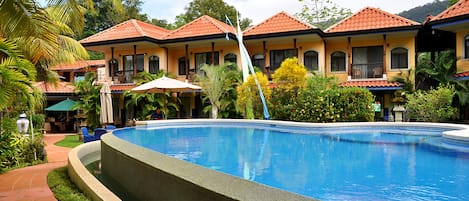 Una piscina al aire libre, sillones reclinables de piscina