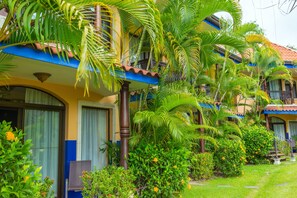 A hotel with multiple balconies, lush greenery, and a well-maintained garden. - Hotel Cuna Del Angel (Bahía Ballena)