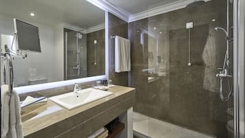 A modern bathroom with a glass-enclosed shower, a large mirror, and a vanity with two sinks.