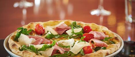 Een pizza met diverse toppings op een wit bord.