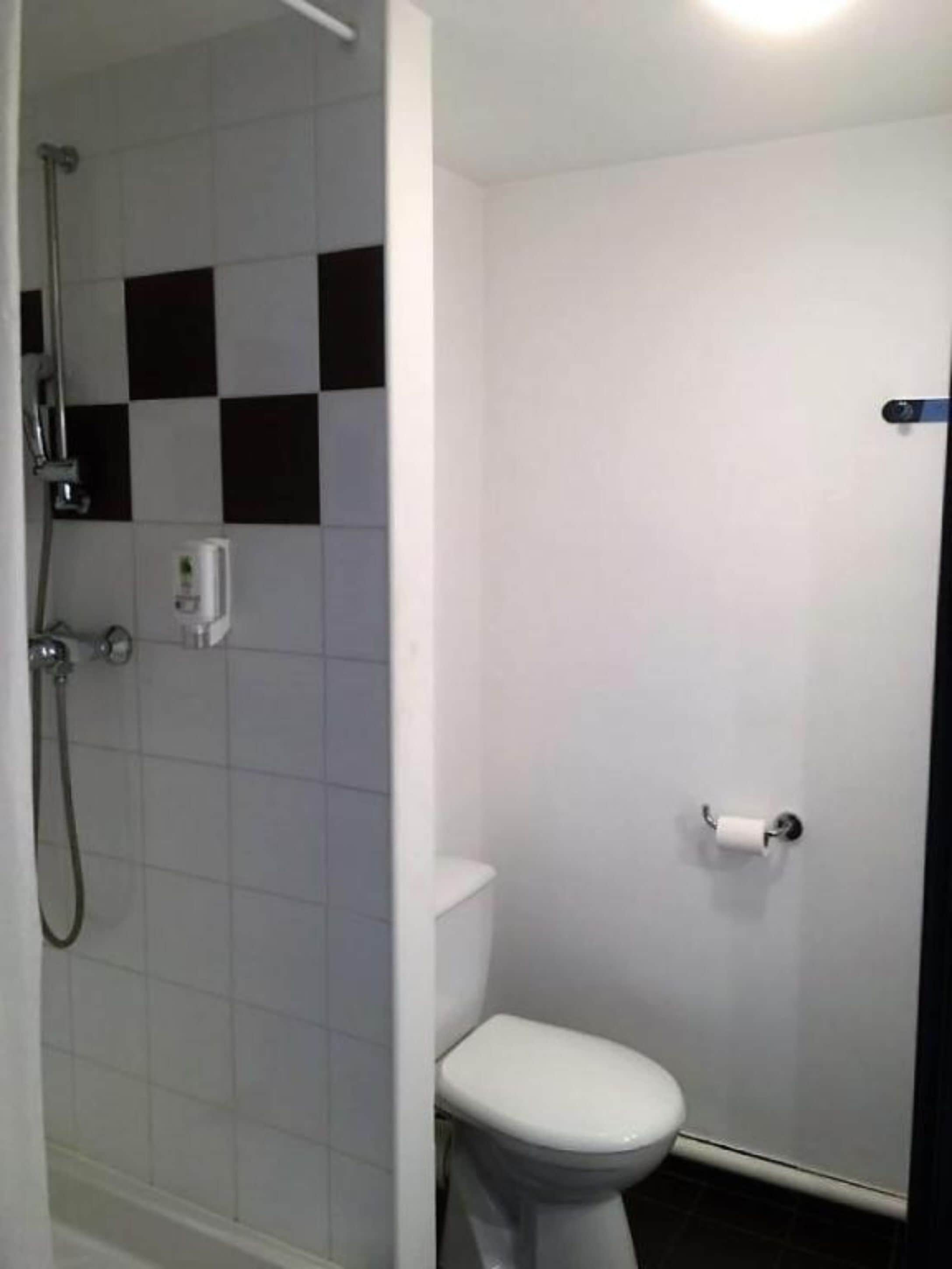 Een bad/douchecombinatie, een haardroger, handdoeken