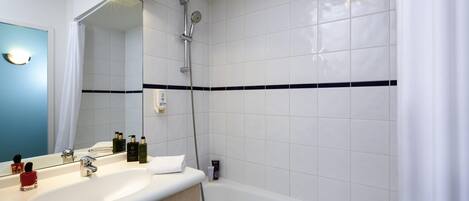 A modern bathroom with a white sink, vanity, and bathtub.