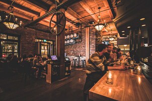 Un bar acogedor con vigas de madera, paredes de ladrillo y un ambiente rústico.
