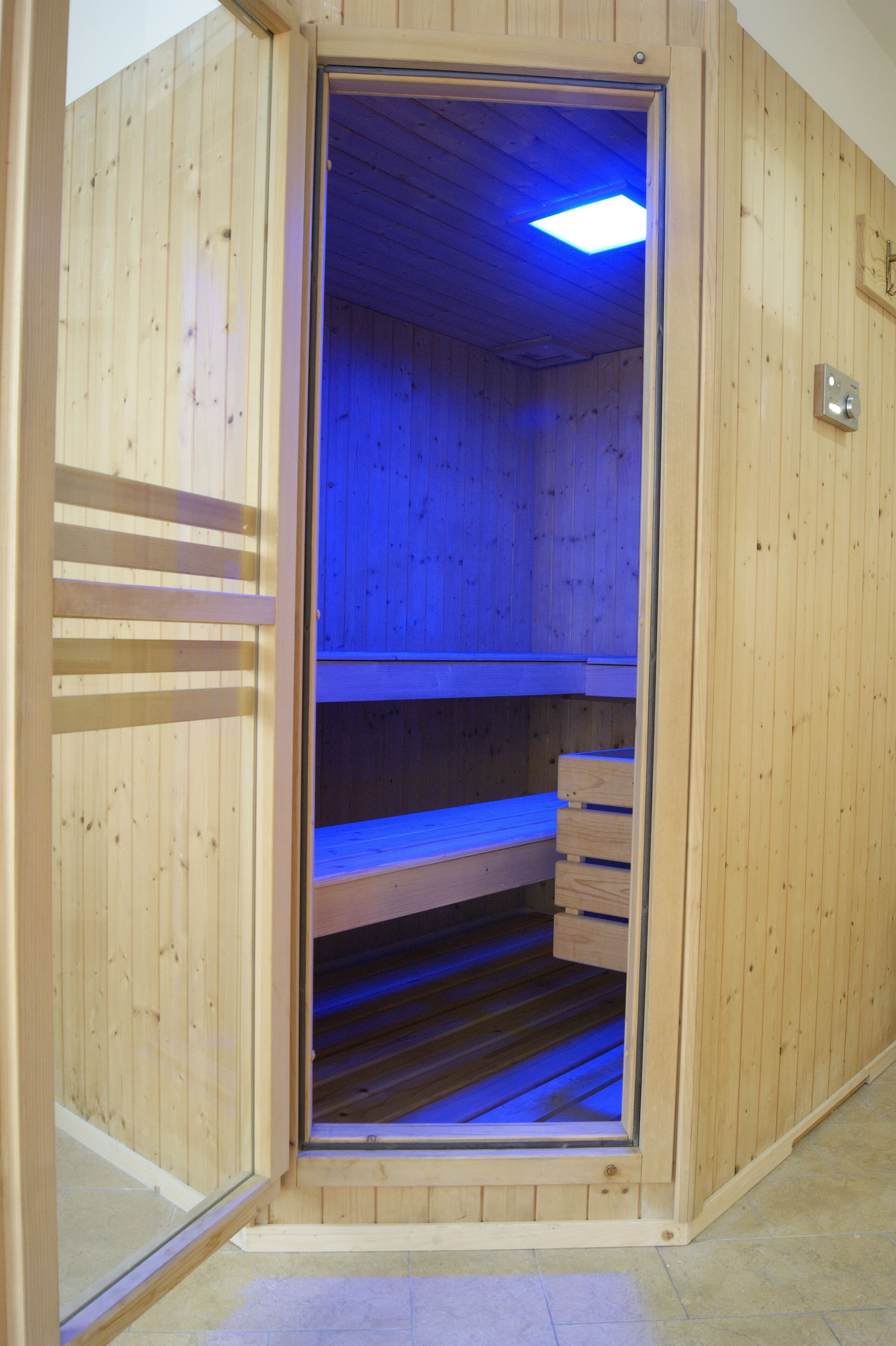 A sauna with wooden walls and a bench inside.