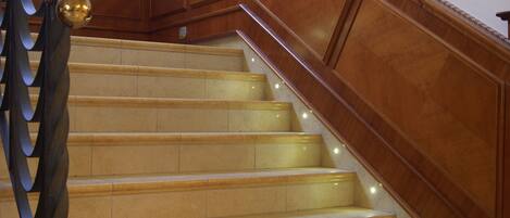 Een statige trap met een houten leuning en een decoratieve balustrade.
