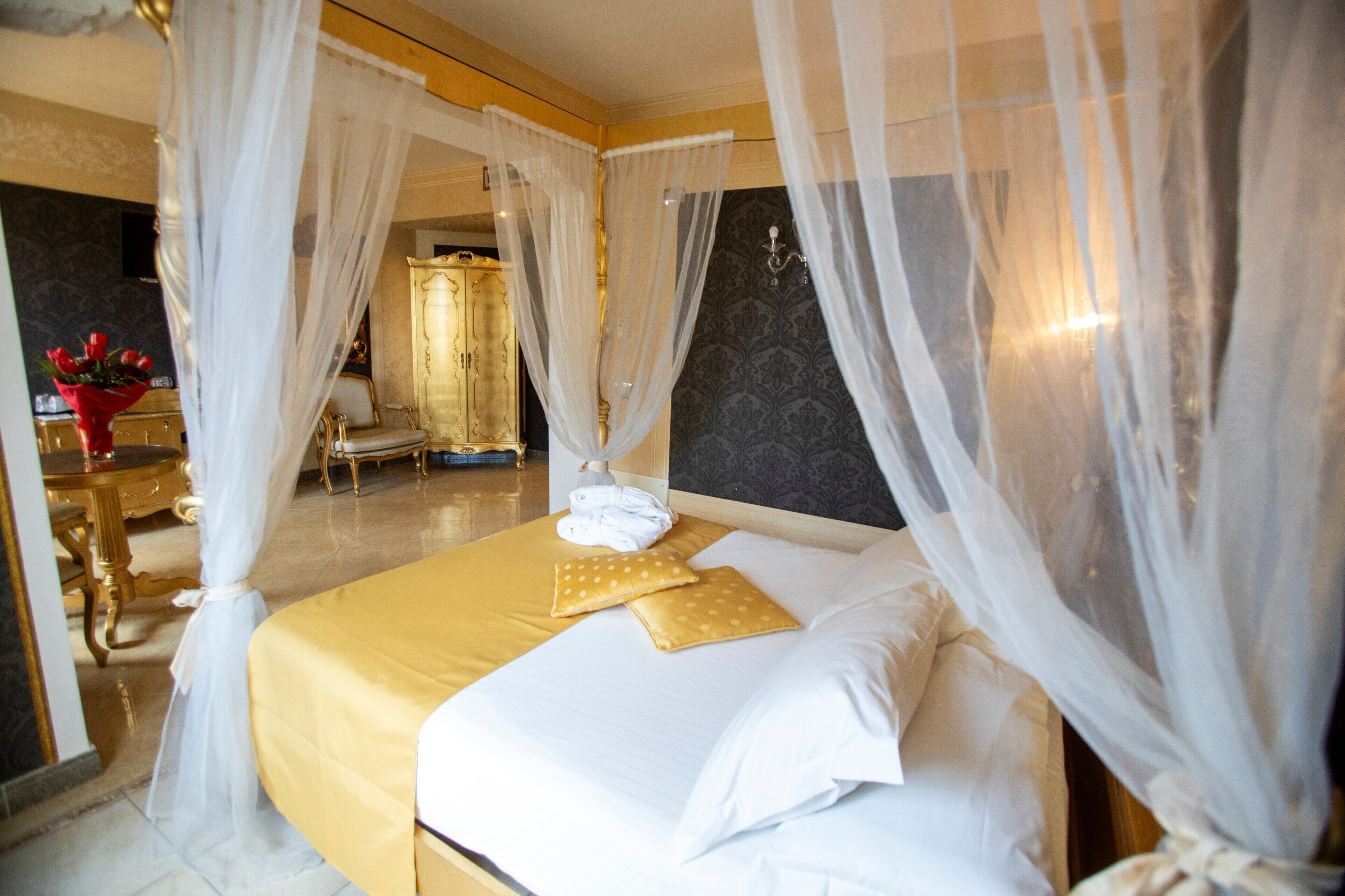 Une chambre d’hôtel comprenant un lit, une table de chevet, une coiffeuse avec un miroir et une chaise.