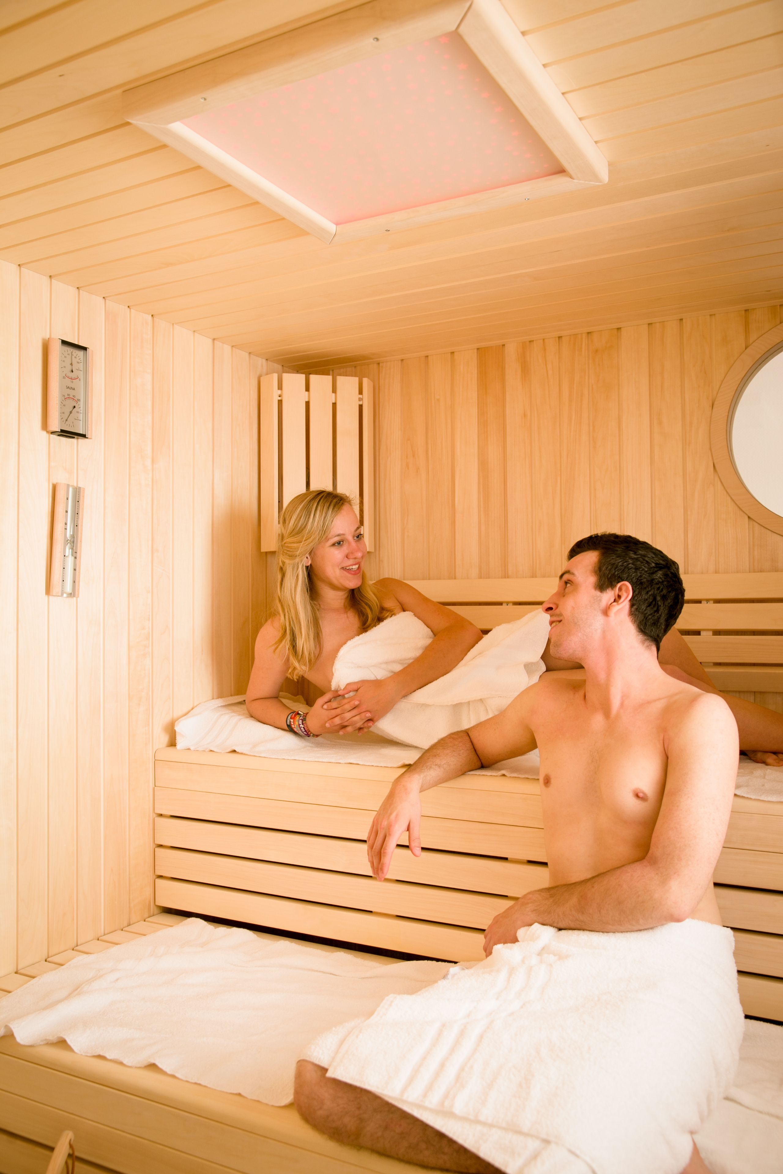 Uma sala de sauna com paredes e bancos de madeira.