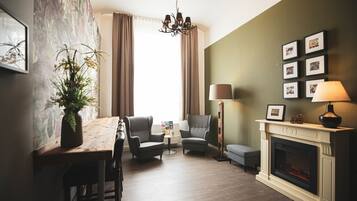Un salon avec une cheminée, une table à manger avec des chaises, un canapé et une lampe.