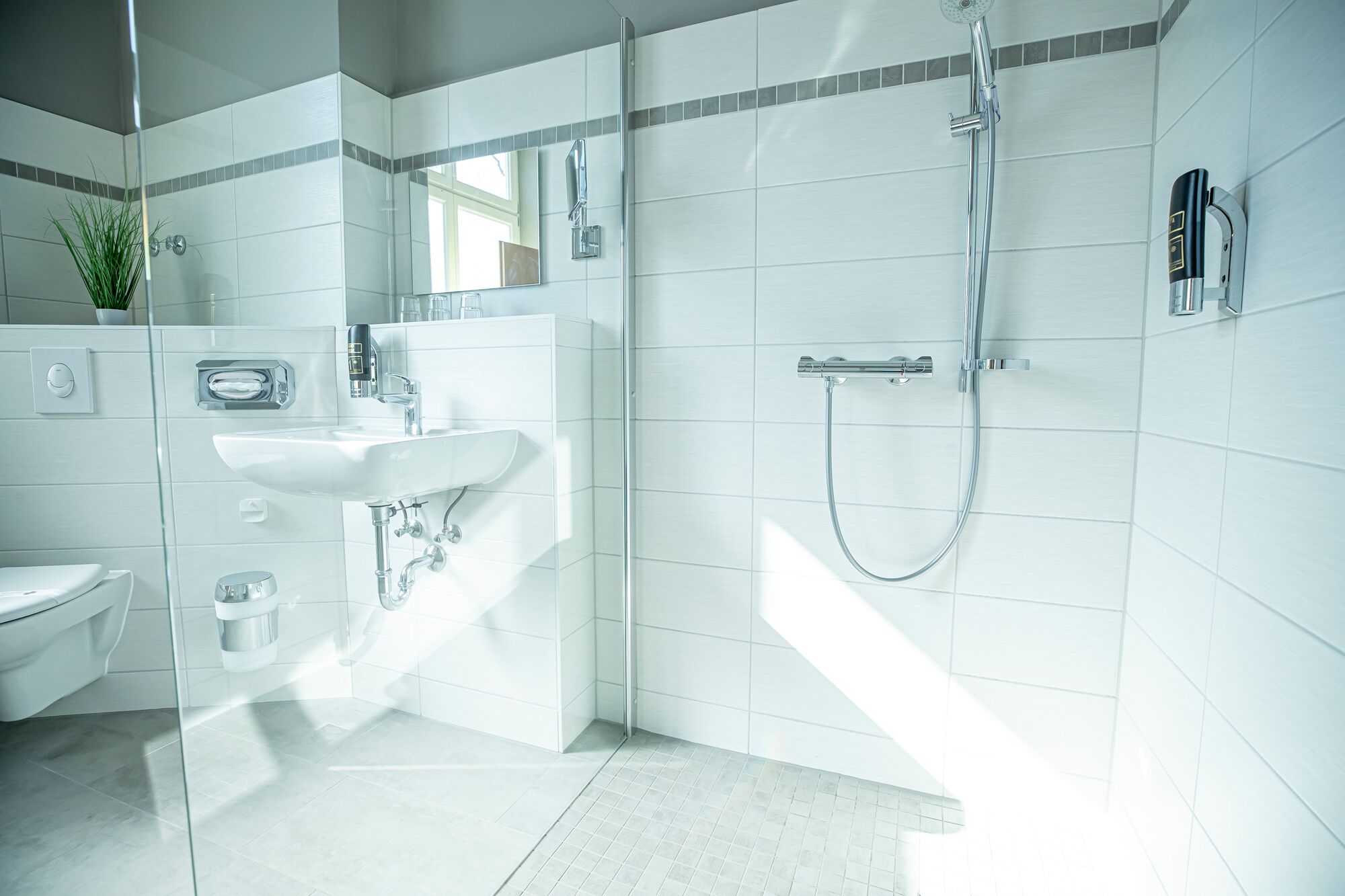 A modern bathroom with a glass shower enclosure, a sink, and a toilet.