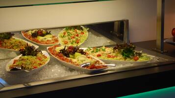 A buffet with various dishes on ice, including salads, meats, and vegetables.