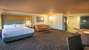 Una habitación de hotel con una cama, un sofá, una mesita y una silla.