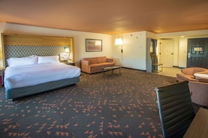 Une chambre d’hôtel avec un lit, un canapé, une petite table et une chaise.