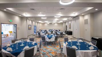 A conference room with multiple tables set for dining, equipped with chairs and table settings.