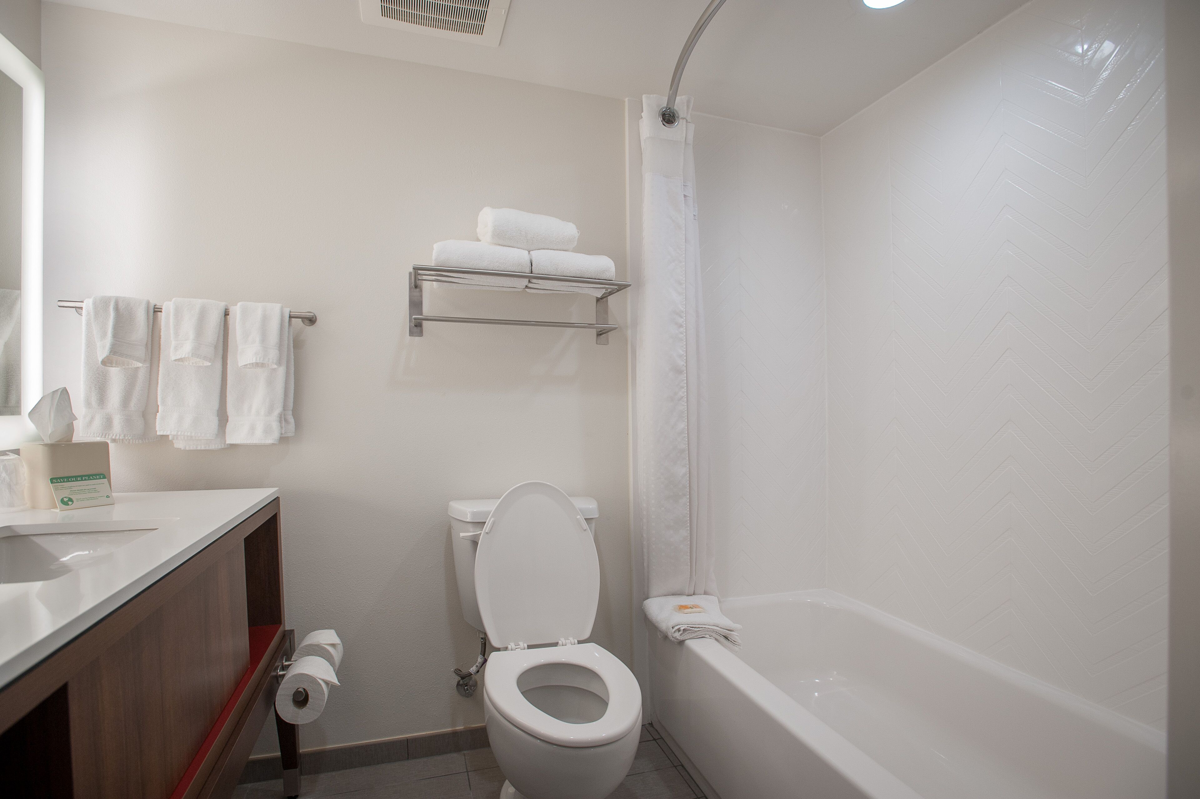 Un baño moderno con inodoro, lavamanos y bañera.