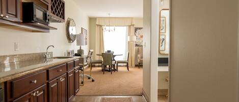 A spacious kitchen with wooden cabinets, a microwave, and a dining area with a table and chairs.
