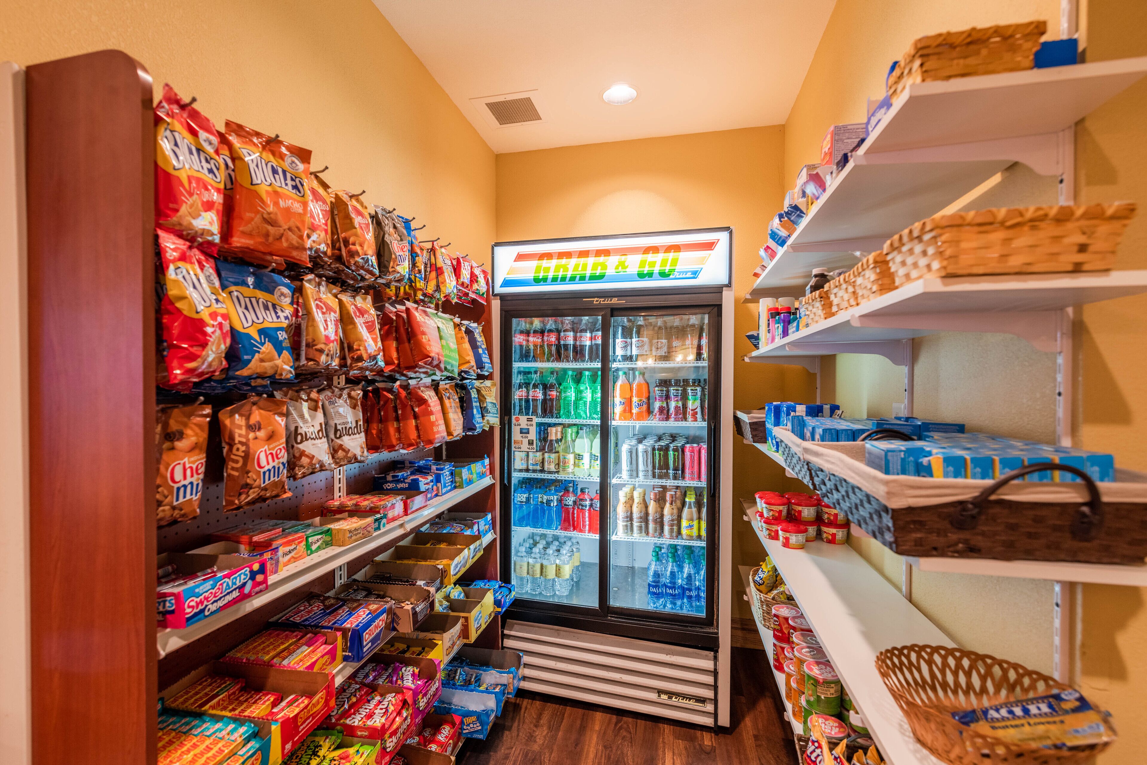 Uma área de distribuição automática com lanches e bebidas, incluindo pacotes de snacks e garrafas.